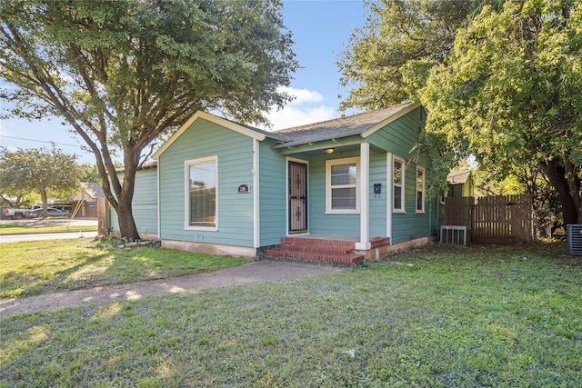 bungalow-style house featuring central AC and a front yard