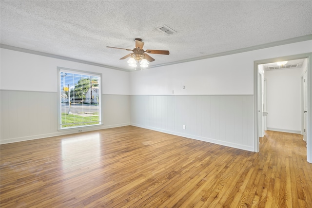 unfurnished room featuring ceiling fan, ornamental molding, a textured ceiling, and light hardwood / wood-style floors