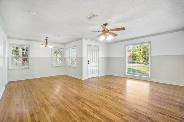 unfurnished living room with ceiling fan with notable chandelier, light hardwood / wood-style floors, crown molding, and a textured ceiling