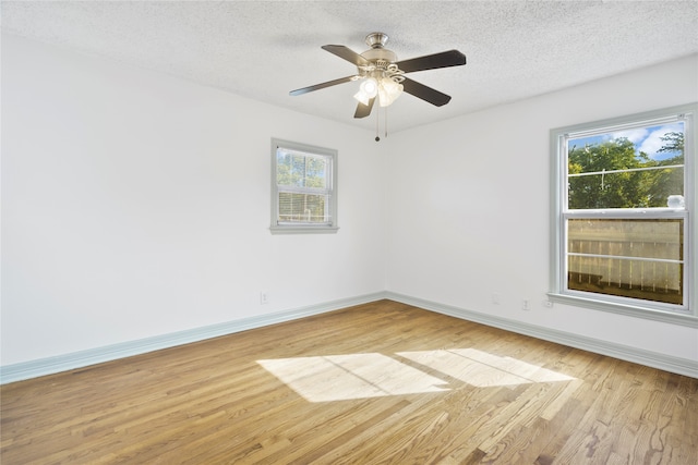 empty room with a textured ceiling, light hardwood / wood-style floors, and ceiling fan