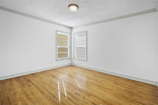 unfurnished room featuring a textured ceiling, ornamental molding, and hardwood / wood-style floors