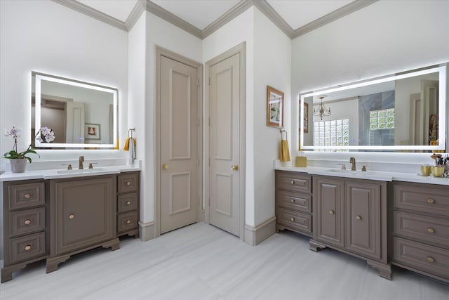 bathroom with a notable chandelier, ornamental molding, and vanity