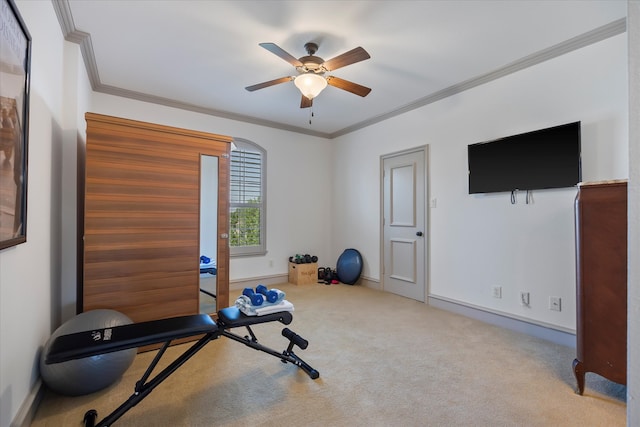 exercise area featuring ceiling fan, light colored carpet, and crown molding