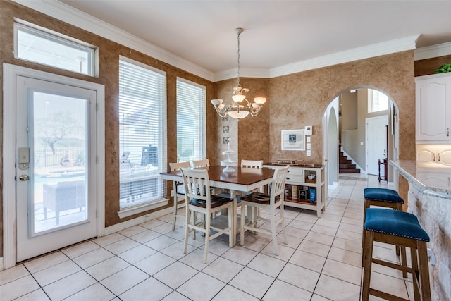 dining area featuring a notable chandelier, light tile patterned floors, and crown molding