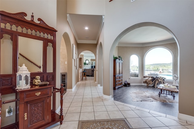 entrance foyer with crown molding, light hardwood / wood-style flooring, and wine cooler