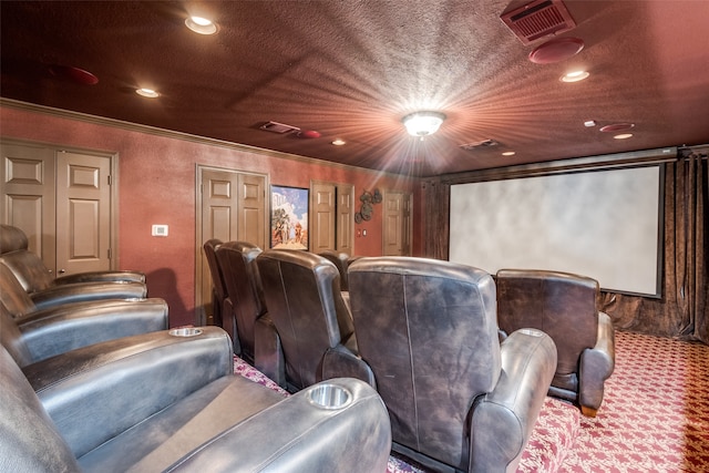 carpeted home theater room featuring a textured ceiling and crown molding