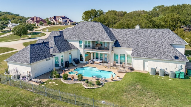 back of property with a lawn, a balcony, a fenced in pool, and a patio area