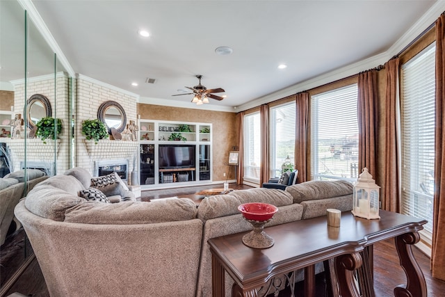 living room featuring ceiling fan, ornamental molding, a fireplace, and hardwood / wood-style floors