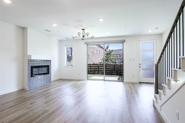 unfurnished living room featuring an inviting chandelier and light wood-type flooring