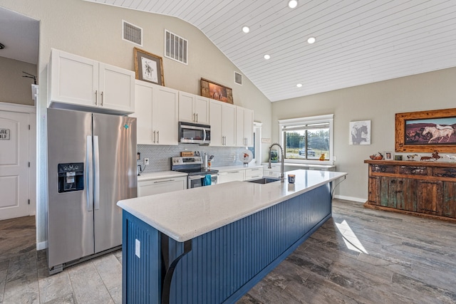 kitchen featuring sink, a breakfast bar, a kitchen island with sink, appliances with stainless steel finishes, and wooden ceiling