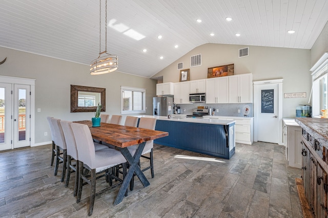 dining area with high vaulted ceiling, a wealth of natural light, wood ceiling, and dark hardwood / wood-style flooring