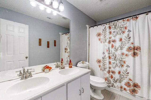 bathroom with vanity, wood-type flooring, a textured ceiling, toilet, and walk in shower