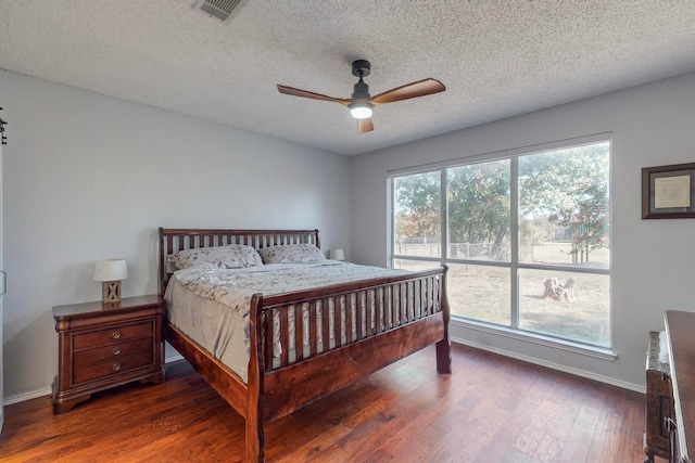 bedroom featuring ceiling fan, dark hardwood / wood-style floors, and a textured ceiling