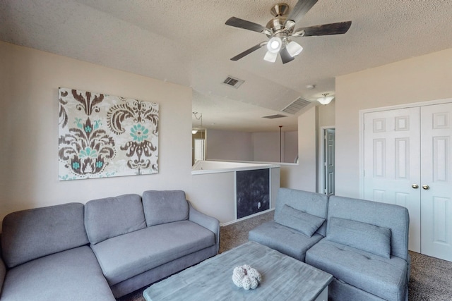 carpeted living room featuring ceiling fan, vaulted ceiling, and a textured ceiling