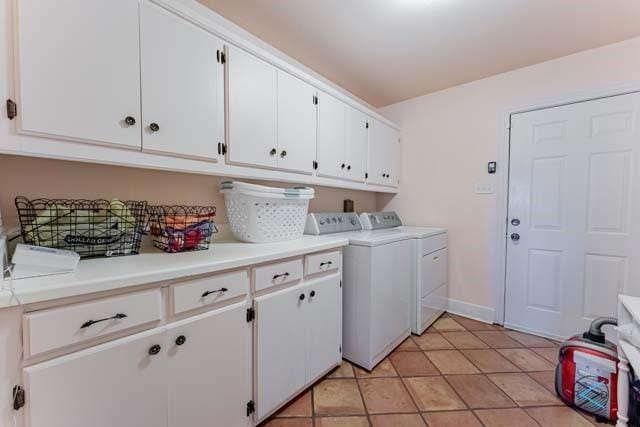 laundry area with light tile patterned flooring, cabinets, and washing machine and dryer