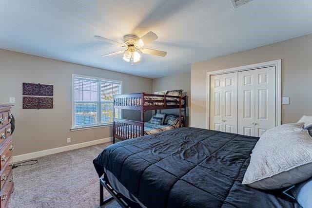 carpeted bedroom featuring ceiling fan and a closet