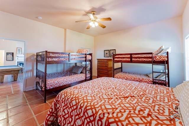 tiled bedroom featuring ceiling fan