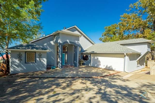 ranch-style house with stucco siding, concrete driveway, and an attached garage