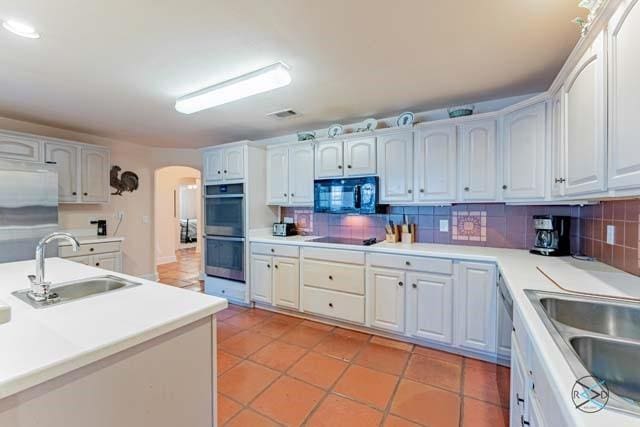 kitchen featuring white cabinetry, sink, tasteful backsplash, and black appliances