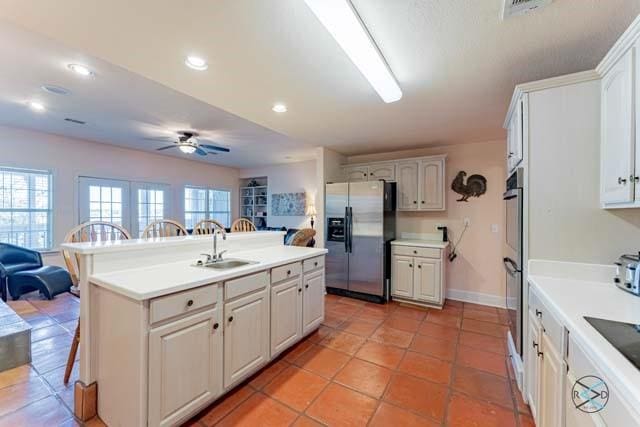 kitchen featuring white cabinetry, stainless steel appliances, sink, and a breakfast bar area