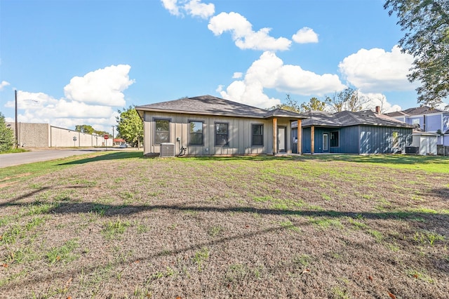 view of front of property featuring a front lawn and central AC