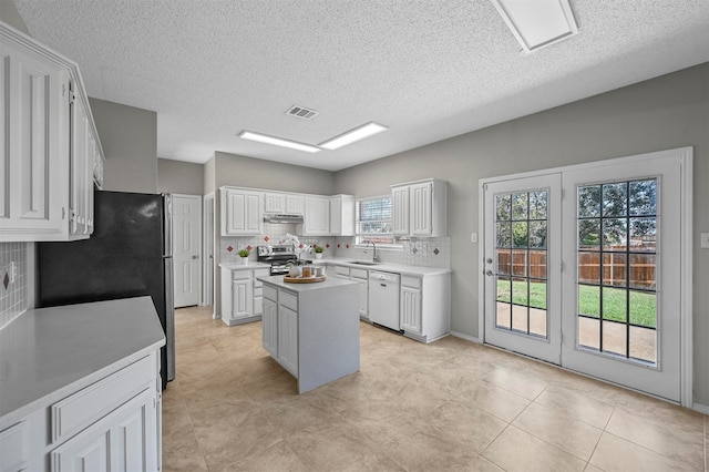 kitchen featuring a center island, sink, white cabinetry, backsplash, and white dishwasher