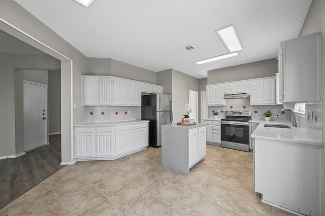 kitchen featuring decorative backsplash, stainless steel appliances, a kitchen island, and sink