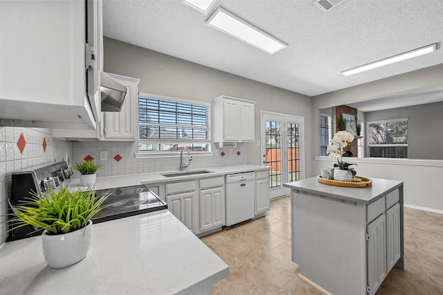 kitchen with white cabinets, white dishwasher, a center island, and a healthy amount of sunlight