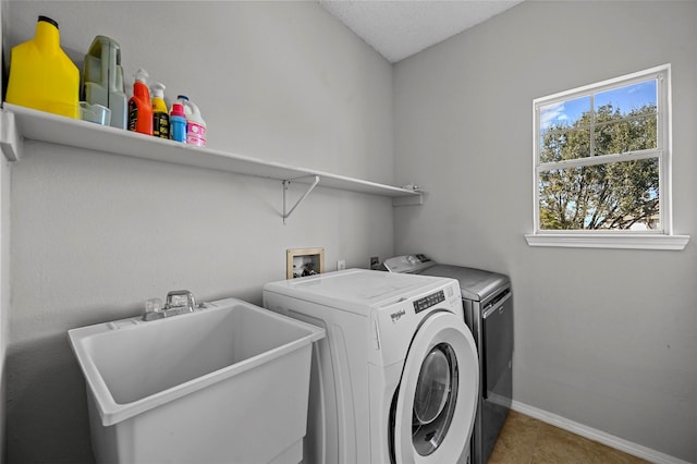 clothes washing area with a textured ceiling, sink, tile patterned floors, and washing machine and dryer