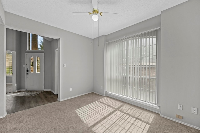 spare room with a textured ceiling, carpet, and ceiling fan