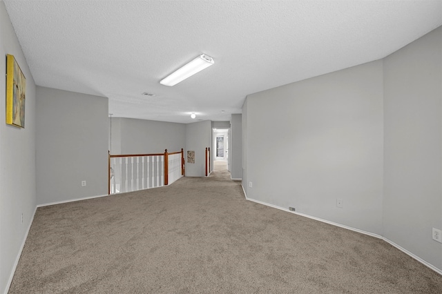 empty room featuring carpet and a textured ceiling