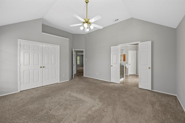 unfurnished bedroom featuring ceiling fan, carpet floors, a closet, and high vaulted ceiling