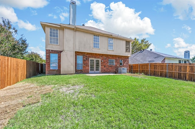 rear view of property with french doors, a yard, a patio, and central AC