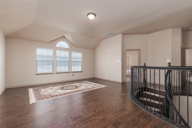 unfurnished room featuring lofted ceiling and dark hardwood / wood-style flooring