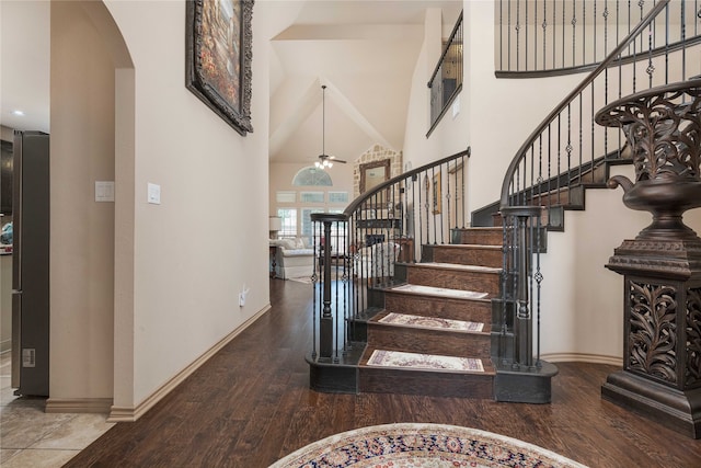 stairway featuring a towering ceiling and hardwood / wood-style floors