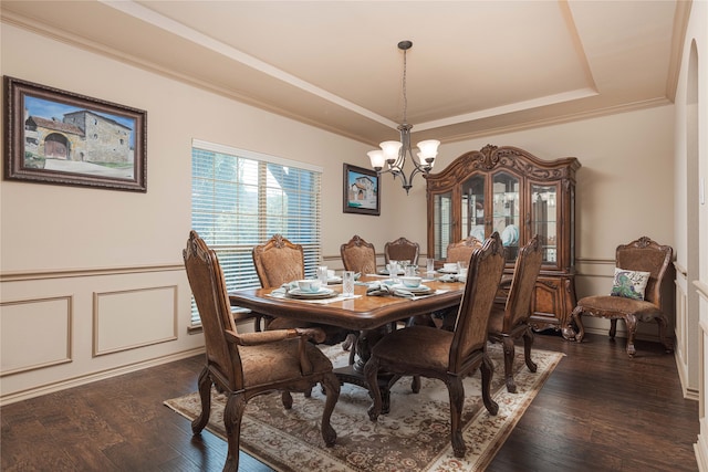 dining space with a raised ceiling, an inviting chandelier, crown molding, and dark hardwood / wood-style flooring