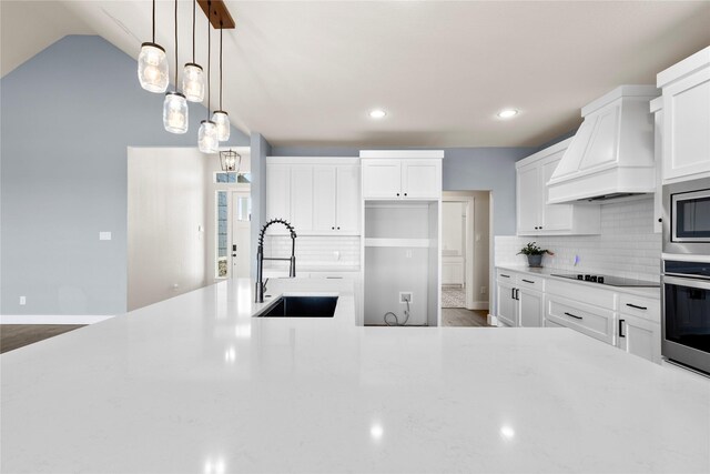 kitchen with sink, dark wood-type flooring, premium range hood, white cabinetry, and appliances with stainless steel finishes