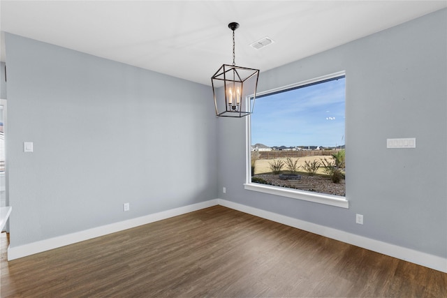 unfurnished dining area with a chandelier and hardwood / wood-style floors