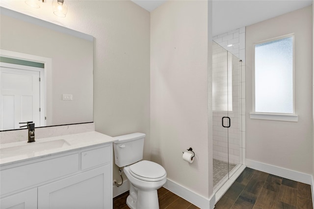 bathroom with hardwood / wood-style flooring, vanity, an enclosed shower, and toilet