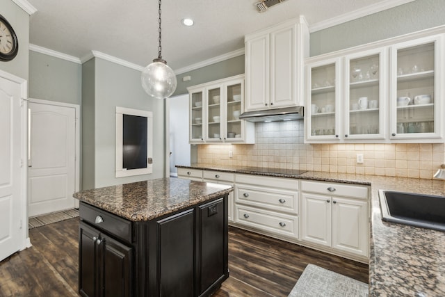 kitchen featuring dark stone counters, black electric cooktop, and white cabinetry