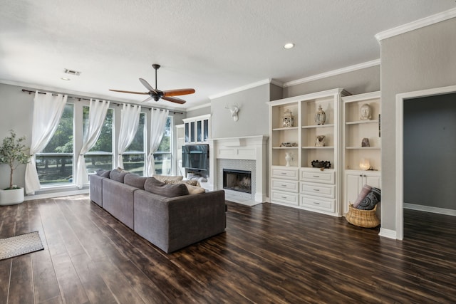 living room featuring ceiling fan, a textured ceiling, dark hardwood / wood-style flooring, and ornamental molding