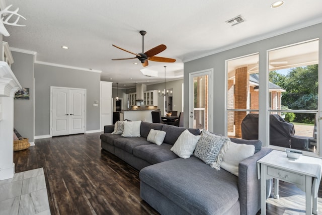 living room featuring ornamental molding, ceiling fan with notable chandelier, and wood-type flooring