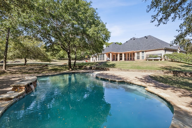 view of swimming pool featuring a lawn, pool water feature, and a patio