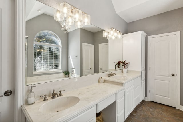 bathroom with vanity, a chandelier, and vaulted ceiling