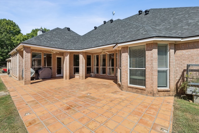 rear view of property featuring ceiling fan and a patio