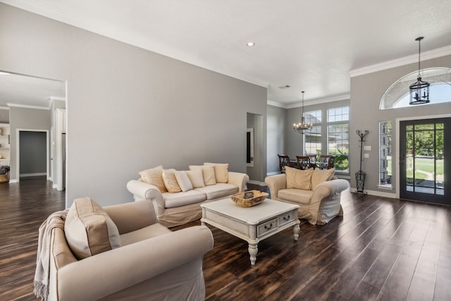 living room featuring dark hardwood / wood-style flooring, ornamental molding, and a chandelier