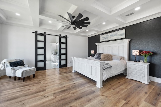 bedroom with ceiling fan, light hardwood / wood-style flooring, beam ceiling, and a barn door