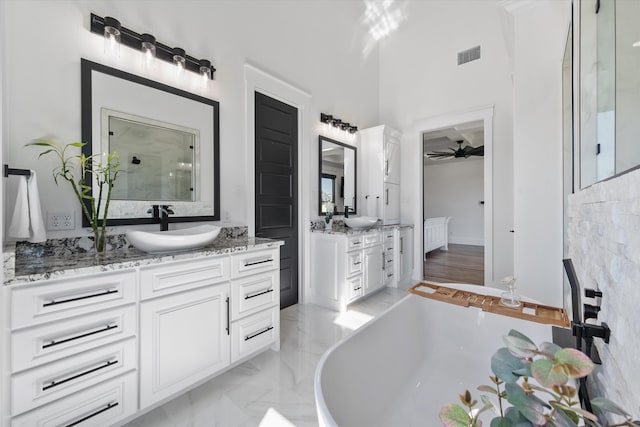 bathroom with plus walk in shower, ceiling fan, and vanity