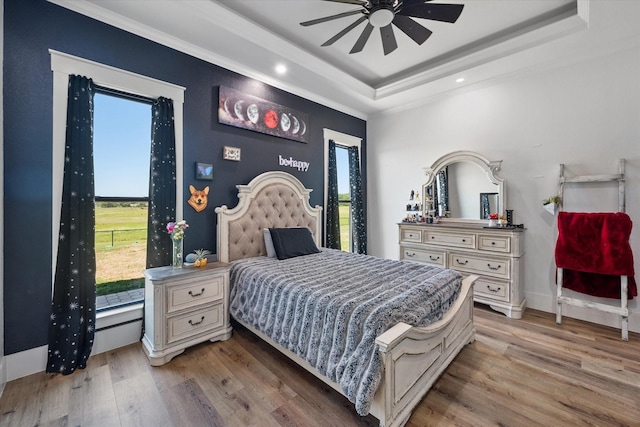 14098 County Road 2858, Eustace, TX 75124 - bedroom with recessed lighting, a tray ceiling, multiple windows, and light wood-style flooring