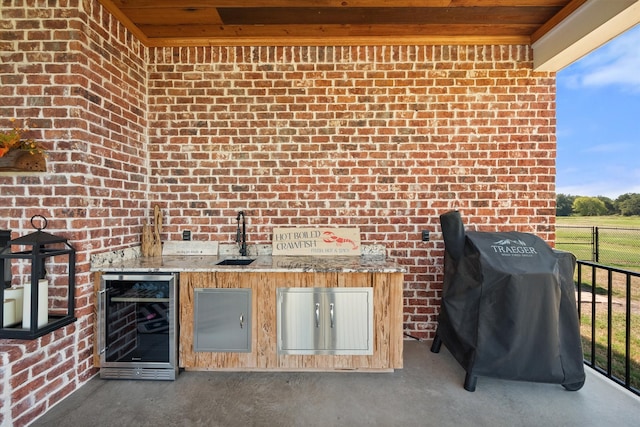 view of patio with area for grilling, beverage cooler, and sink